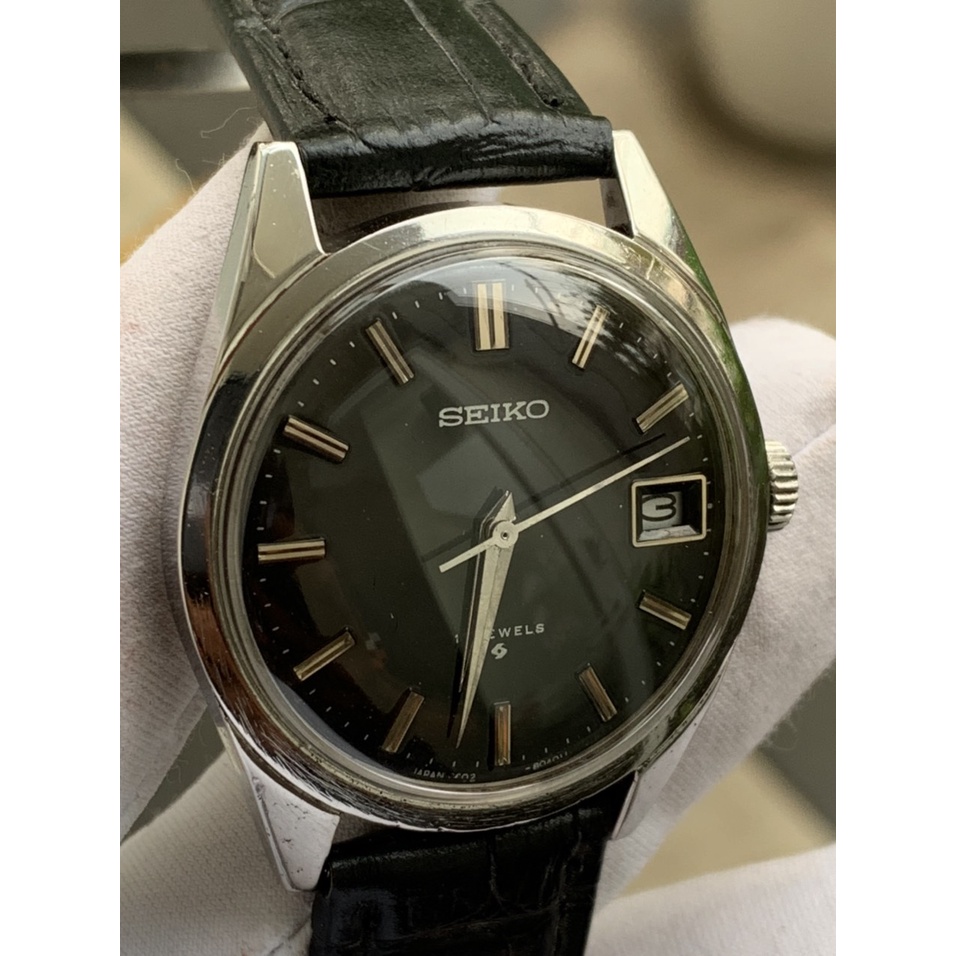 Đồng hồ nam SEIKO cơ cót 17 jewles, có ô cửa lịch, mặt màu đen, dây da thiết kế đơn giản của Nhật