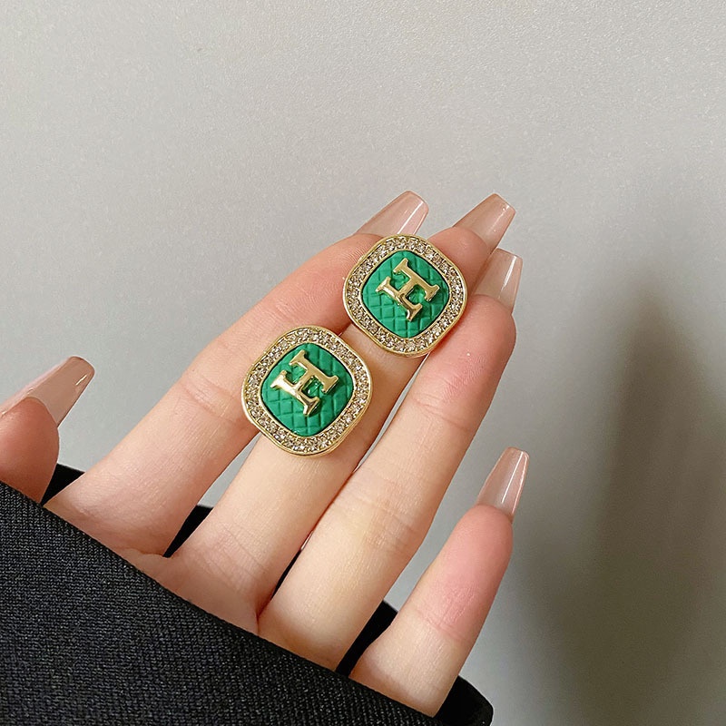 Hoa tai chữ H đính đá nền xanh thương hiệu