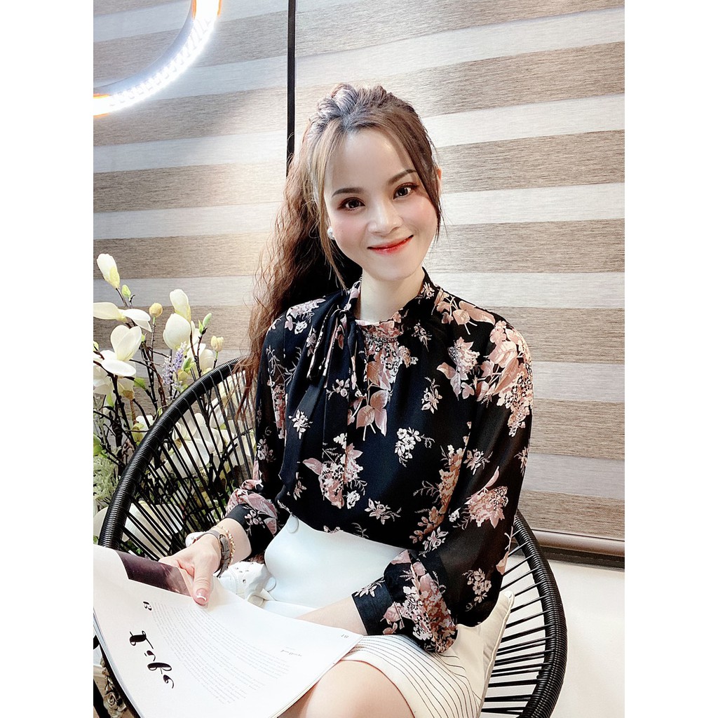 Áo sơ mi nền đậm, hoạ tiết hoa lá trẻ trung, cổ tròn, kết hợp dây nơ nữ tính