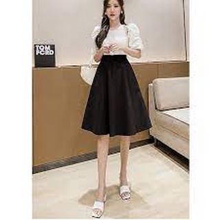 Chân váy xòe dài đến đầu gối màu đen, không họa tiết