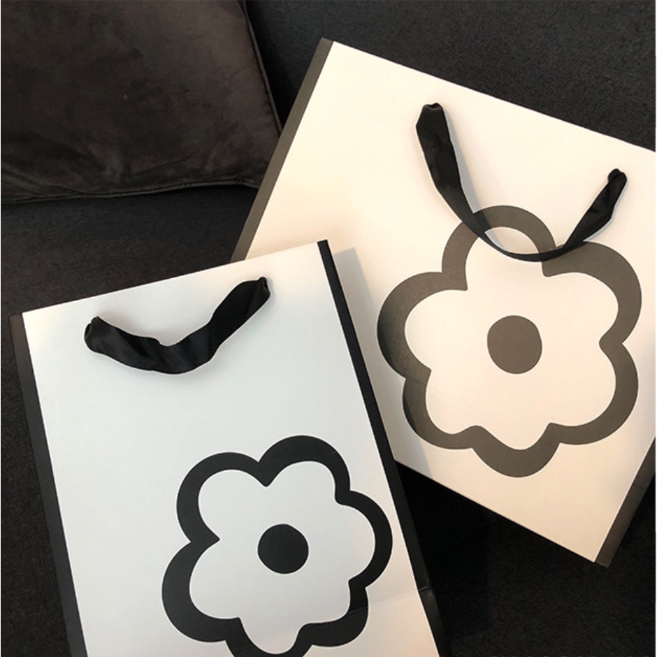 Túi giấy bìa cứng màu trắng kết hợp logo hình HOA, quai xách vải đen mềm