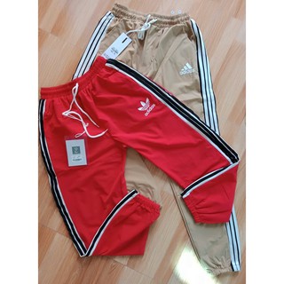 Quần gió nam nữ phối sọc trắng đen bo gấu in logo dáng jogger trẻ trung năng động RumHana
