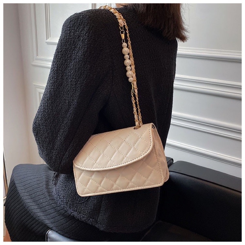 Túi xách nữ đeo chéo kẹp nách da thêu có nắp dây xích phối hạt ngọc nhân tạo.