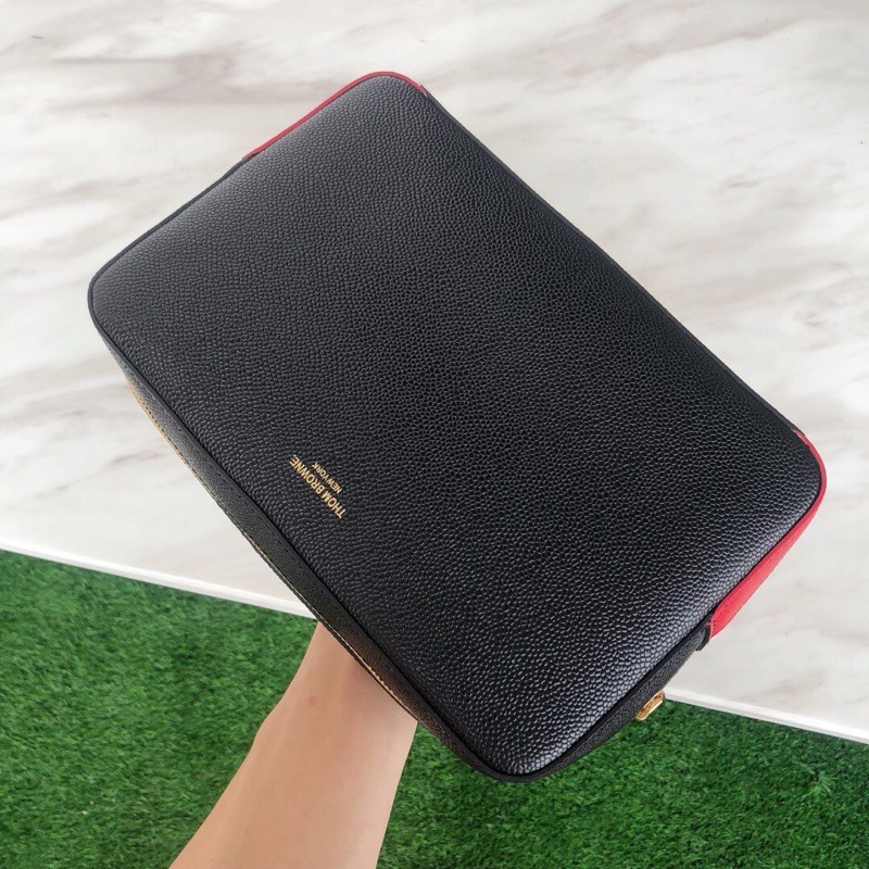 Túi clutch mới làm bằng da bò vân bóng. Thương hiệu này luôn giữ được sự chú trọng và hấp dẫn thom browne