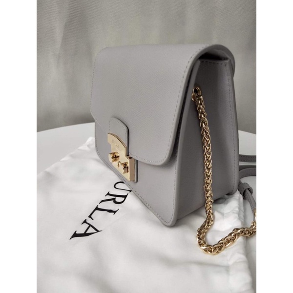 Túi đeo chéo nữ FURLA METROPOLIS  chi tiết chuẩn, từ đường keo mũi chỉ đến logo khắc đều sắc nét. Size 21cm