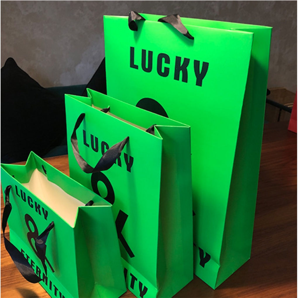 Túi giấy bìa cứng xanh logo đen "LUCKY & ETERNITY", quai vải mềm