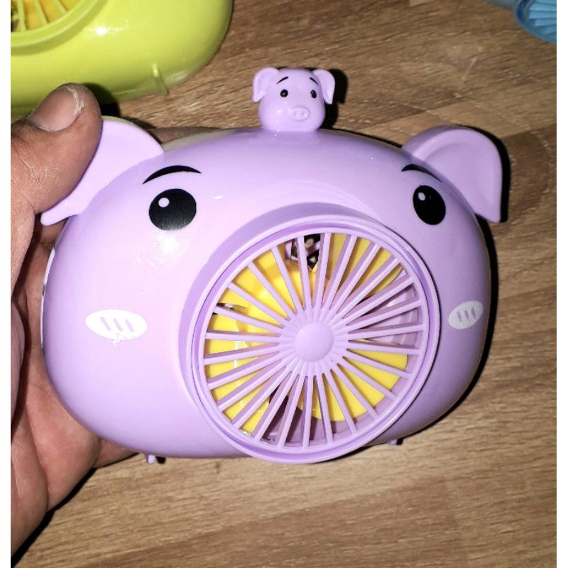 Một chiếc quạt để bàn mini bằng nhựa có dây đeo tặng kèm pin