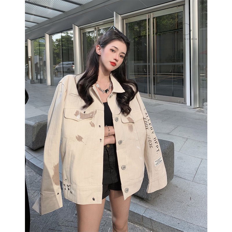 Áo khoác denim màu trắng sữa có vệt màu loang in chữ sau lưng phong cách cá tính