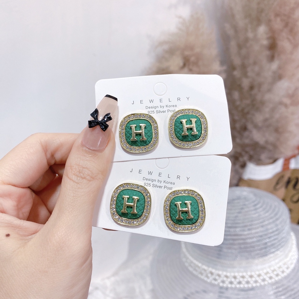 Hoa tai chữ H đính đá nền xanh thương hiệu