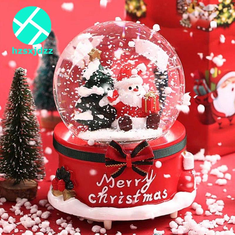 Hộp nhạc có hàng chữ "Merry Christmas" và quả cầu pha lê chứa ông già Noel