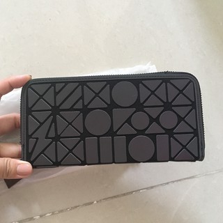 Ví cầm tay đen phản quang dưới ánh đèn hihi
