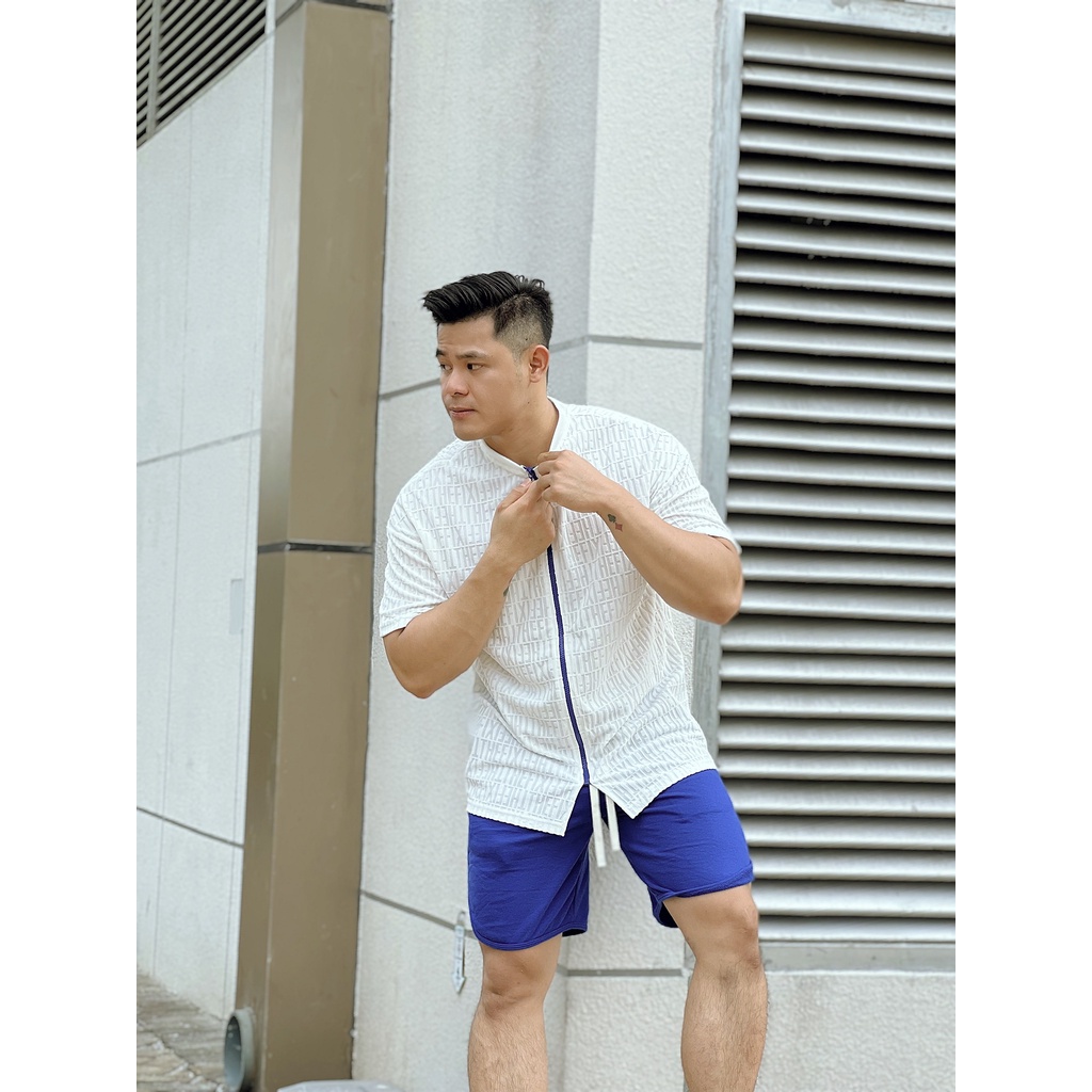 Áo thun thời trang được dệt chữ nổi và khóa zip xanh nổi bật cho các chàng trai cá tính đón mùa hè đầy năng động.