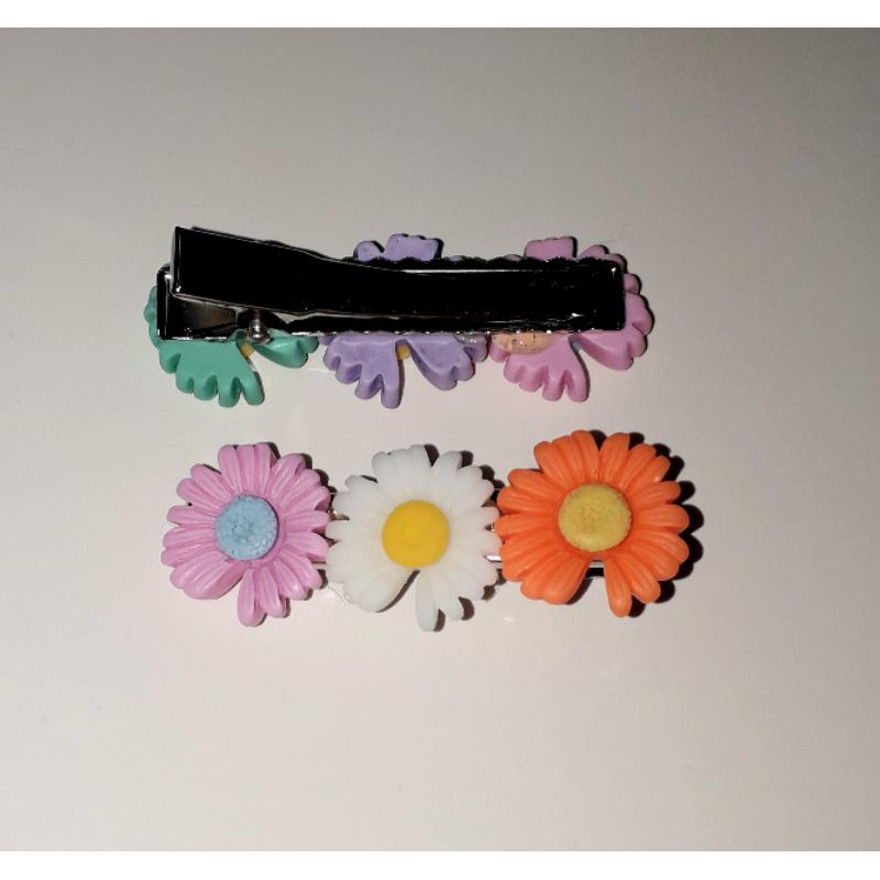 Một chiếc kẹp tóc bằng inox có 3 bông hoa bằng nhựa rất đẹp