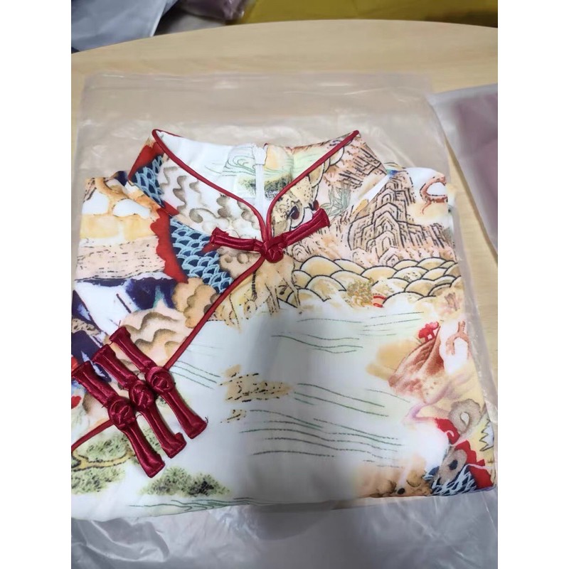 Sườn xám ôm body xẻ tà dáng ngắn. Váy ôm sát body cổ trang hoa viền đỏ
