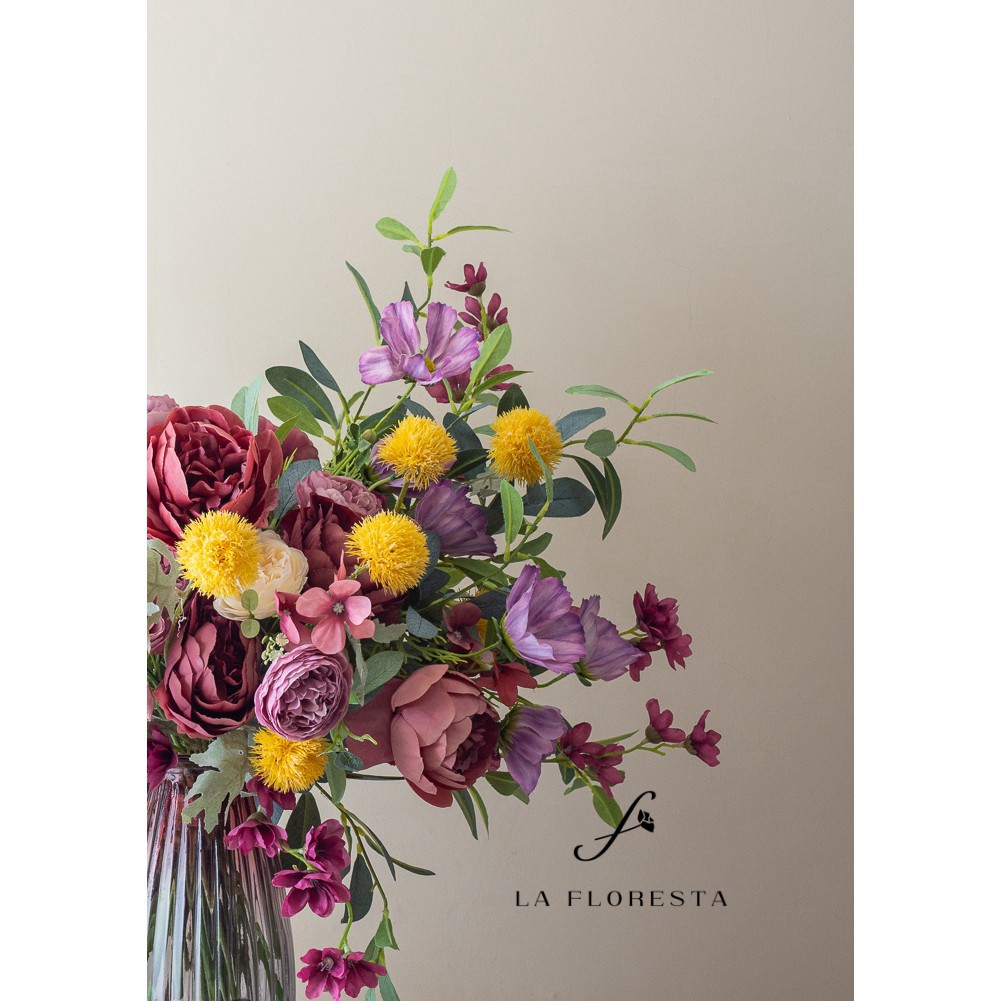 Bình hoa trà màu nâu cắm sẵn trong bình thuỷ, phối hợp với các loại hoa màu tím và vàng, dùng để trang trí nhà cửa