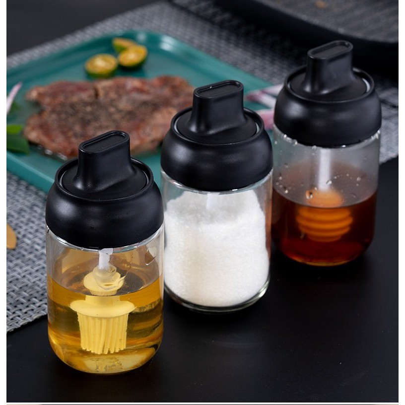 Bình thủy tinh đựng gia vị có nắp nhựa đen kín gắn liền muỗng tiện lợi kích thước 14x6.6cm