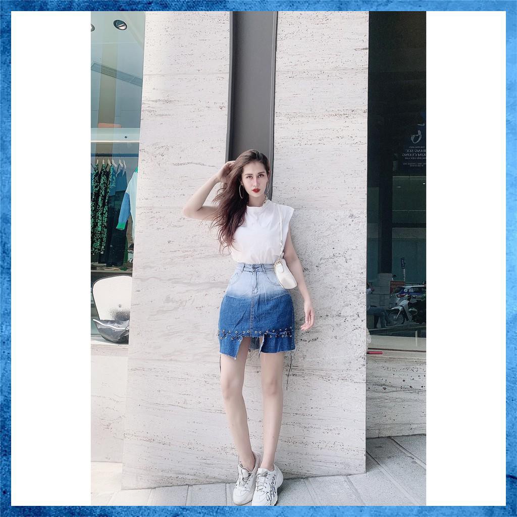 Chân váy denim ngắn, cạp cao loang màu túi chéo, gấu đan dây. Mã V9135
