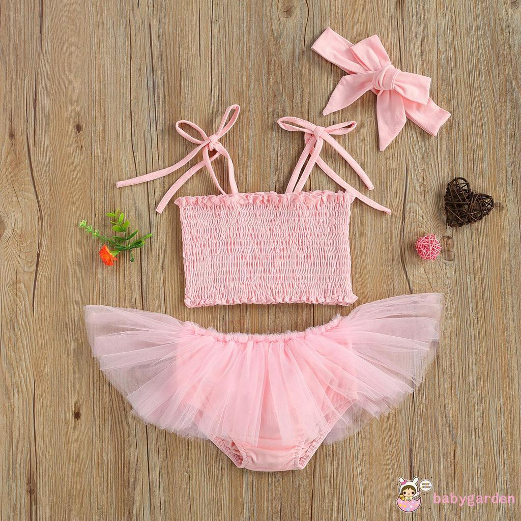 Áo không tay với quần váy ngắn và băng cột tóc thời trang cho bé gái