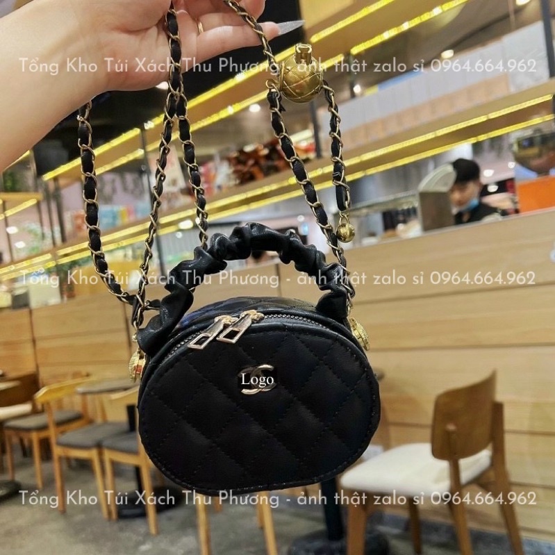 Túi đeo chéo dáng tròn quai nhún trần ô đính logo kèm dây đeo quả chuông siêu xinh