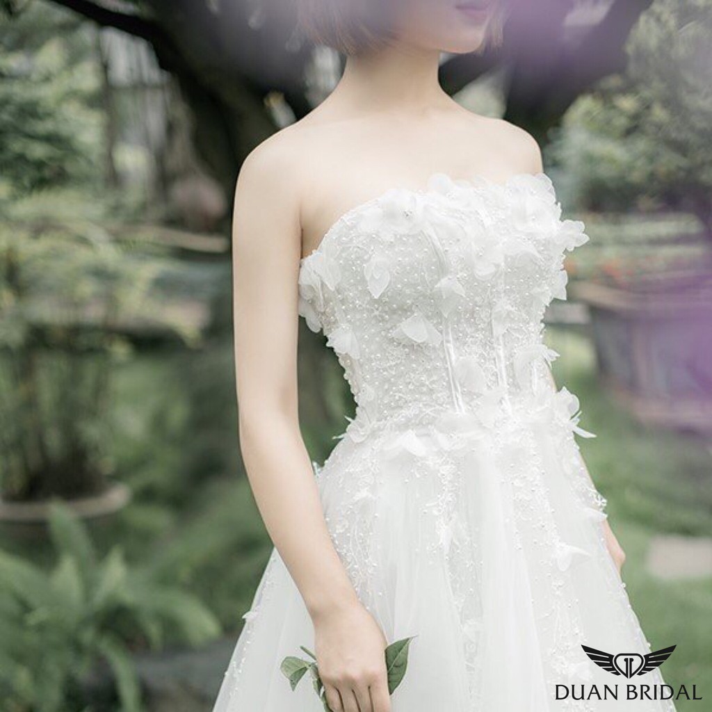 Áo váy cưới màu trắng được thếu bông hoa được làm thủ công trước ngực  tạo nên vẻ đẹp nhẹ nhàng ,thương hiệu DUANBRIDAL