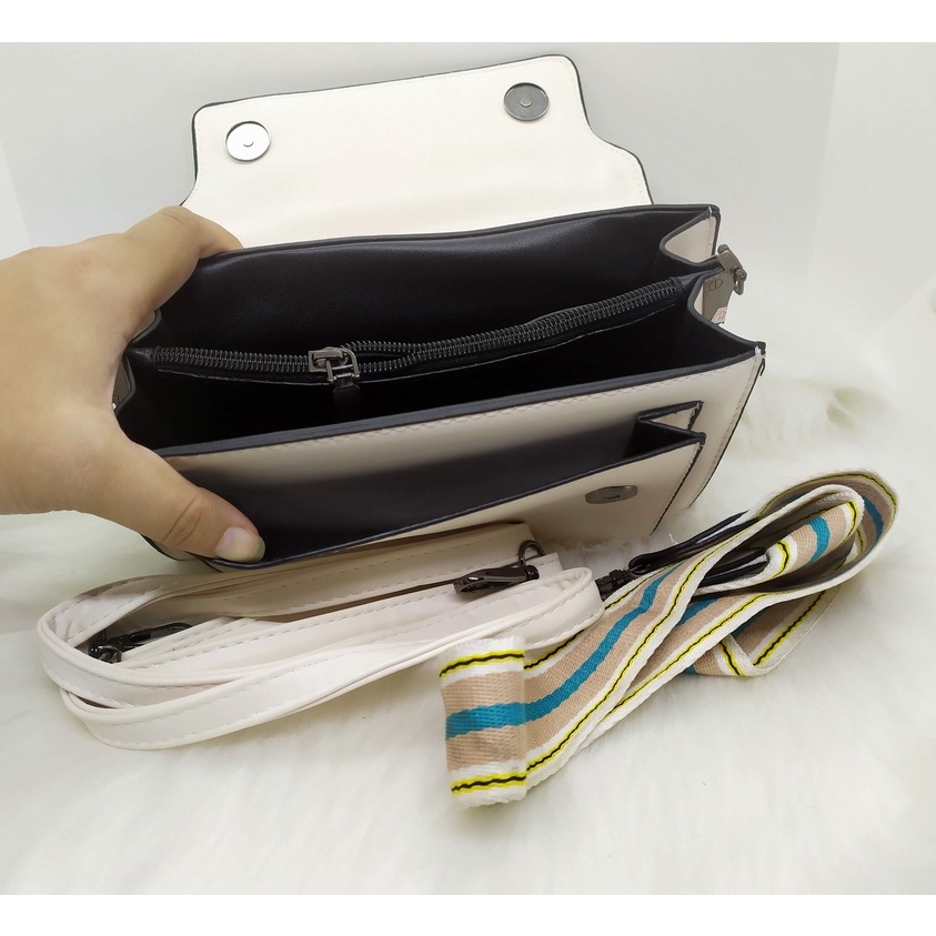 Túi C.K. dạng hộp, chất da màu trắng siêu mềm, có 1 dây da đeo chéo và 1 dây vải bảng to đeo chéo