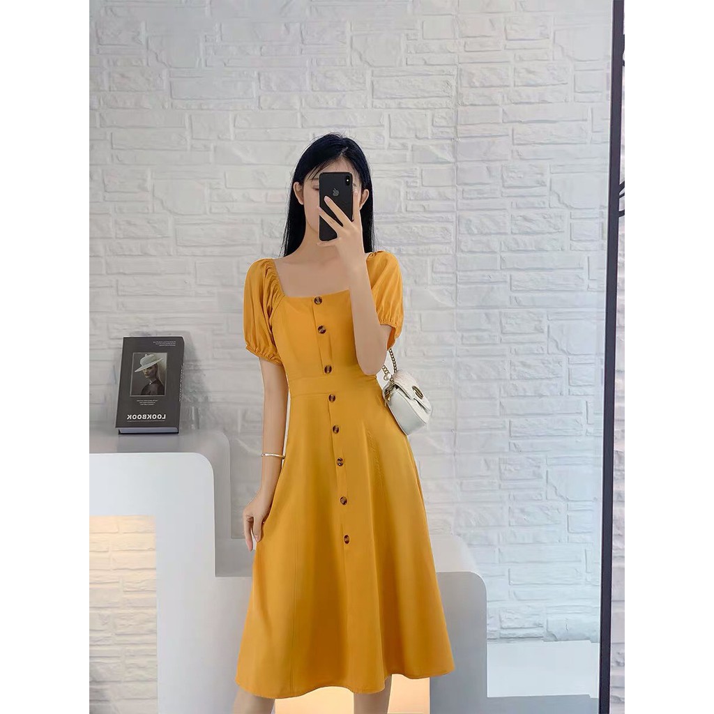 Đầm vàng bẹt vai phối nút xinh MAGB2606203