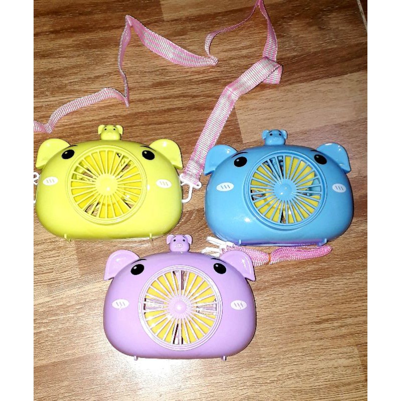 Một chiếc quạt để bàn mini bằng nhựa có dây đeo tặng kèm pin