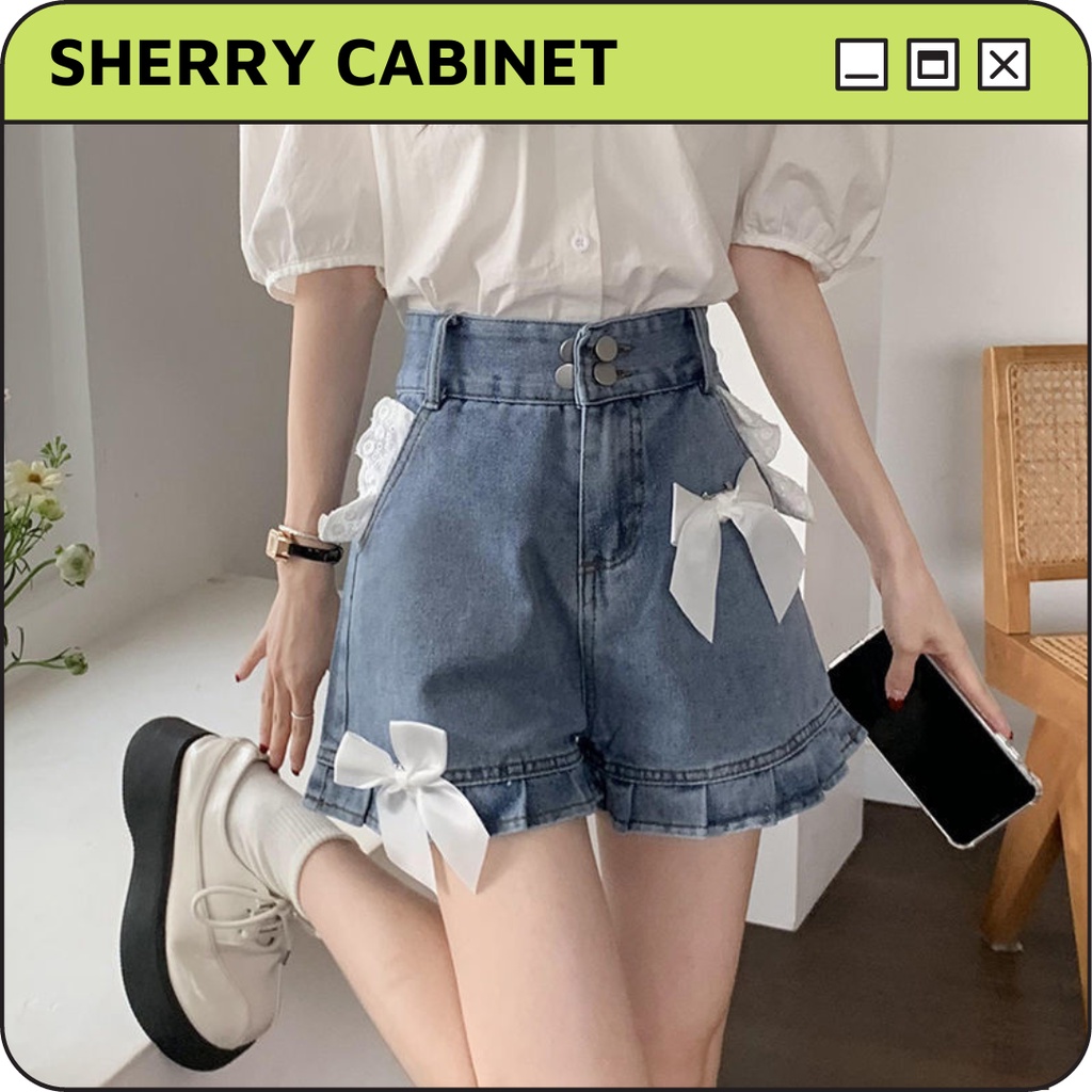 Quần short bò cạp cao nơ lụa trắng gấu quần xếp ly ống rộng dáng chữ A