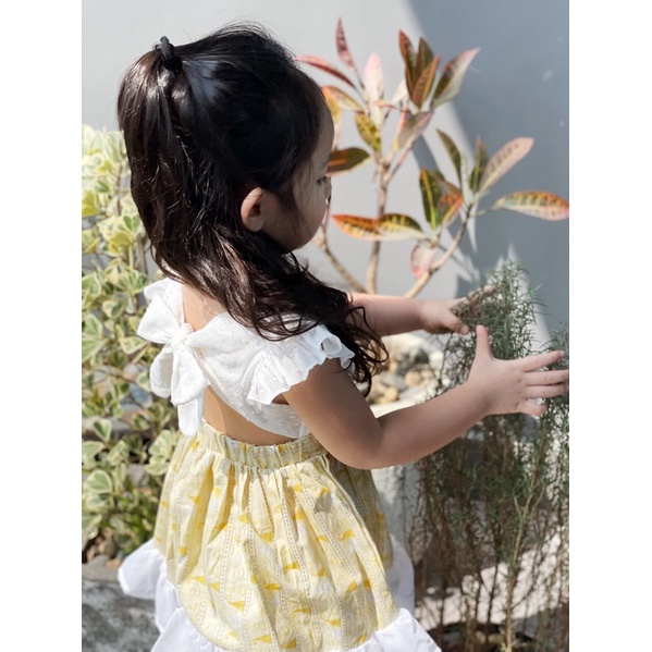 Yếm vàng Lennco buộc nơ sau cho bé gái