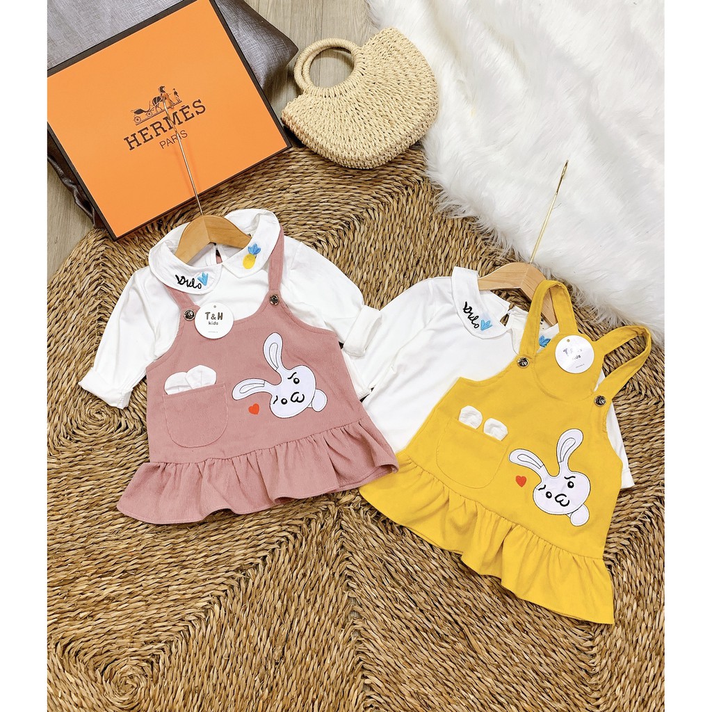 Set trang phục bé gái gồm áo thun trắng dài tay cổ cánh sen, chất thun cotton và váy yếm màu hồng hình thỏ đáng yêu