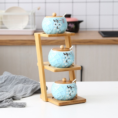 Kệ tre hình thang trên và dưới đựng lọ thủy tinh, lọ đựng gia vị bằng sứ, hộp đựng gia vị, bộ lắc muối, hộp đựng gia vị
