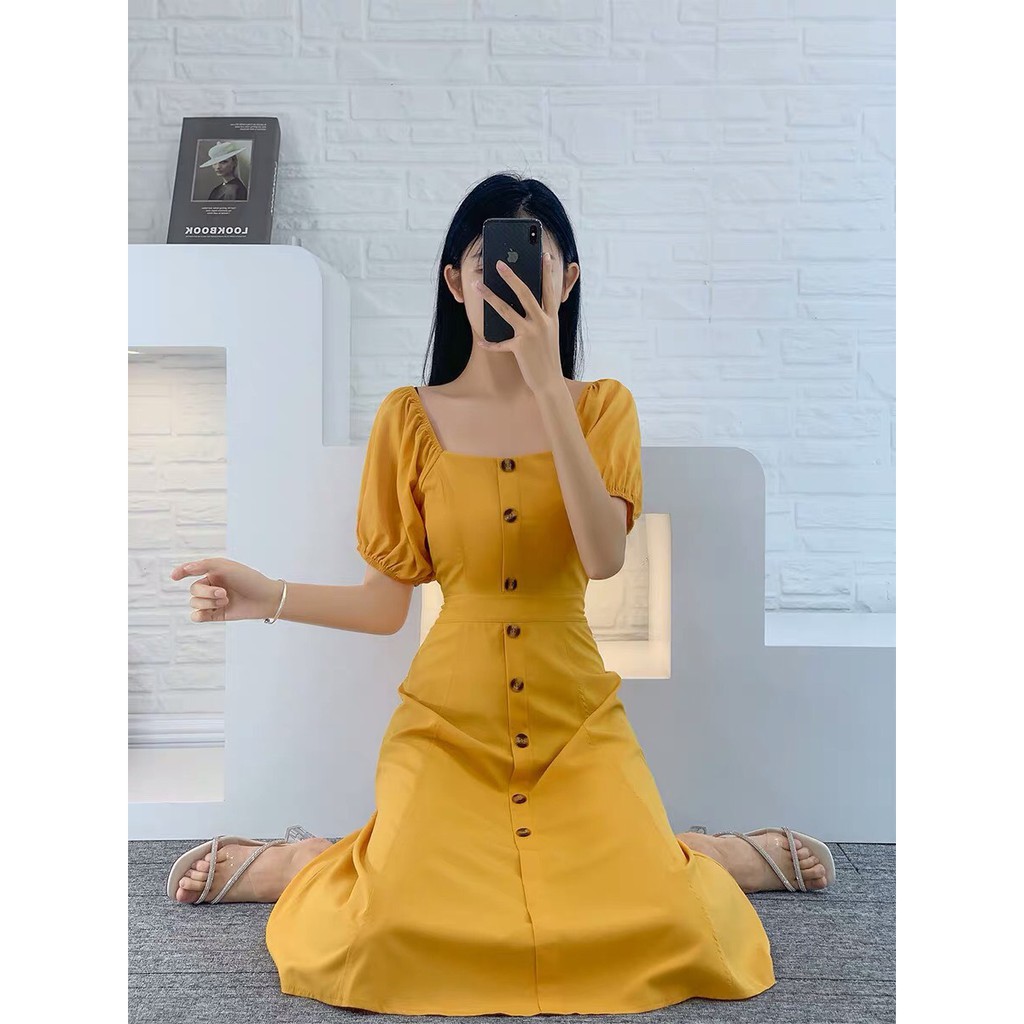 Đầm vàng bẹt vai phối nút xinh MAGB2606203