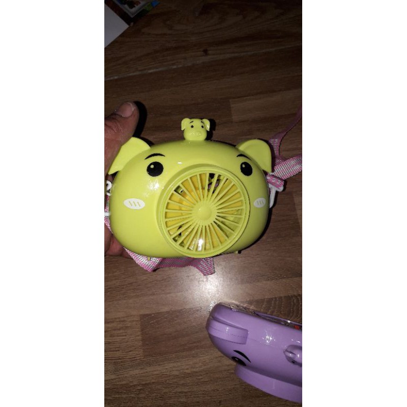 Một chiếc quạt để bàn mini bằng nhựa có dây đeo tặng kèm pin