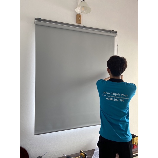 Rèm cuốn kéo tay che nắng cửa sổ trong nhà.