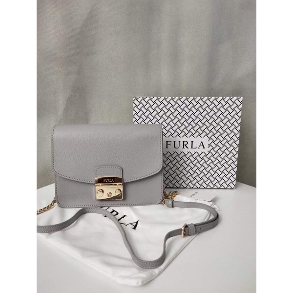 Túi đeo chéo nữ FURLA METROPOLIS  chi tiết chuẩn, từ đường keo mũi chỉ đến logo khắc đều sắc nét. Size 21cm