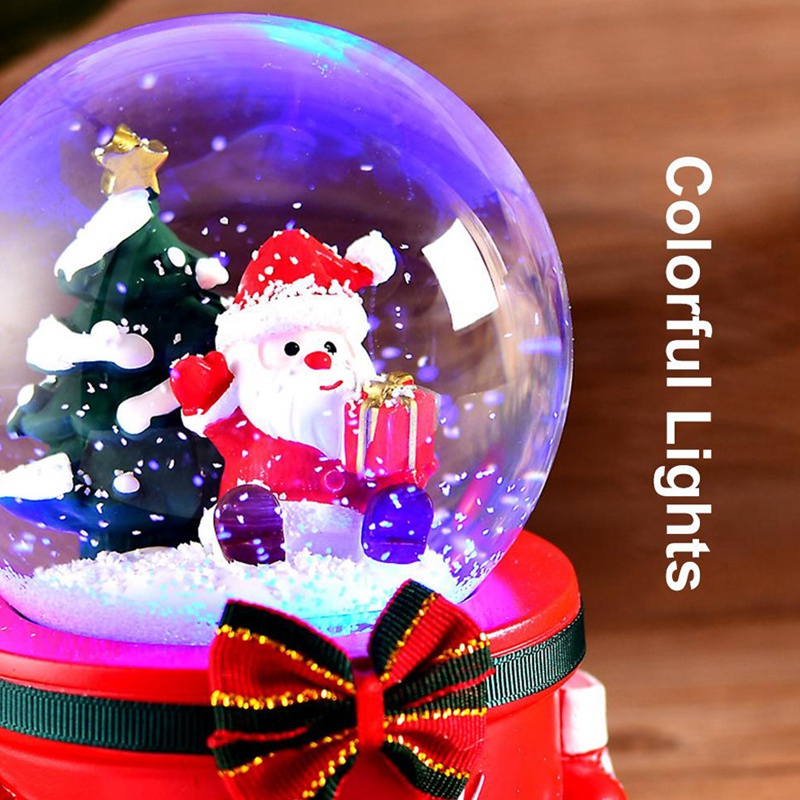 Hộp nhạc có hàng chữ "Merry Christmas" và quả cầu pha lê chứa ông già Noel