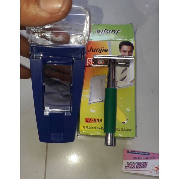 Một cây cạo râu bằng thép không gỉ có kèm lưỡi và mặt kính mini rất tiện