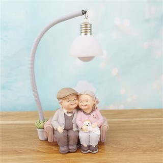 Tượng trang trí ông bà hạnh phúc bên nhau ngồi dưới đèn