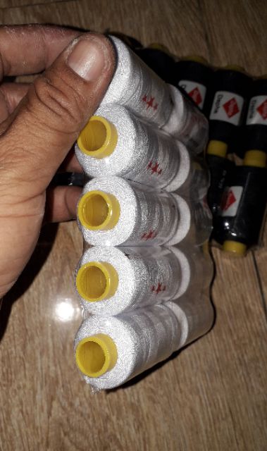 Một cuộn chỉ khâu may vá màu đen hoặc trắng do Việt Nam sản xuất