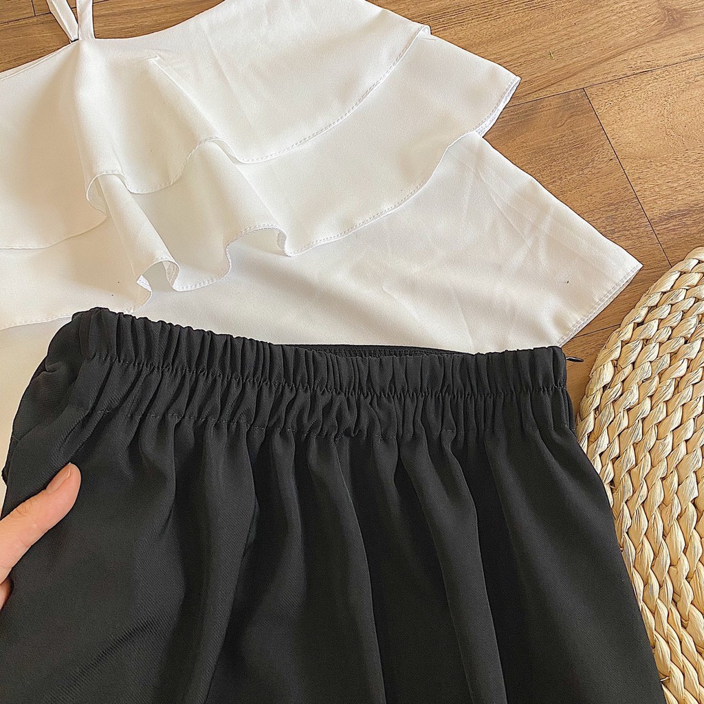 Yumi Set - Set đồ gồm chân váy đen cột nơ đơn giản có Lưng chun co giãn và áo kiểu màu trắng xếp tầng khoe vai