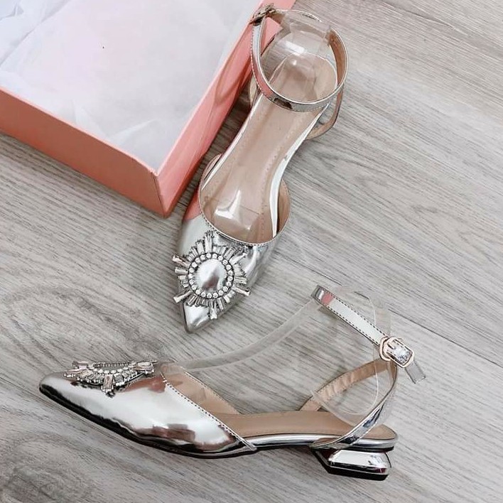 Giày búp bê chất nhựa ánh nhũ bạc có đính đá trang trí hình mặt trời mũi nhọn, gót vuông cao 2 cm có quai quang cổ chân