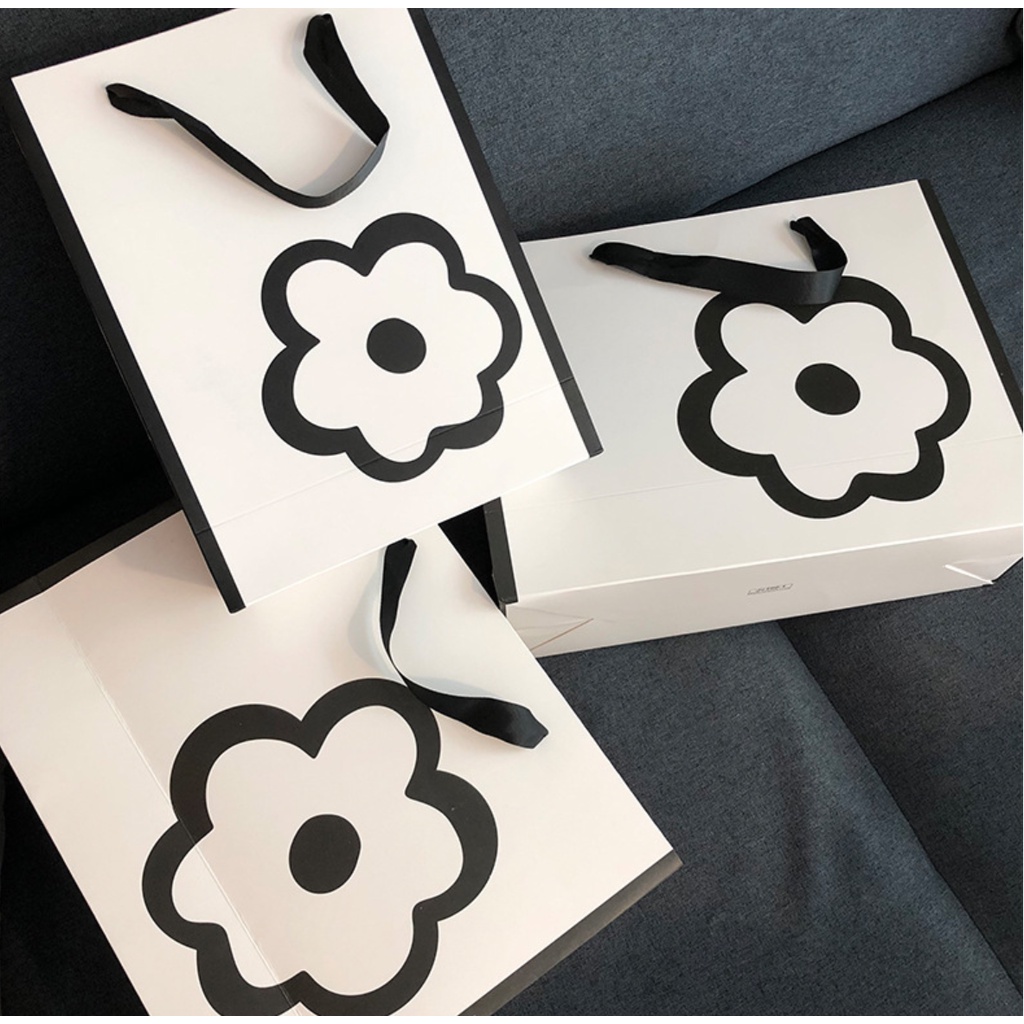 Túi giấy bìa cứng màu trắng kết hợp logo hình HOA, quai xách vải đen mềm