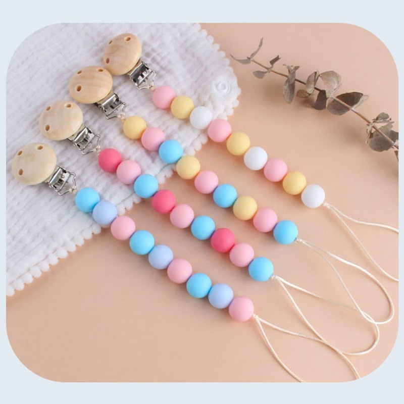 Bộ đồ chơi lục lạc gỗ và dây đeo núm ti em bé bằng silicon