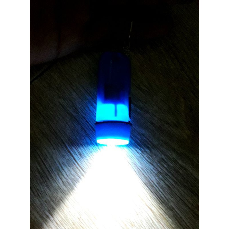 Một cái đèn pin mini làm móc khóa bằng nhựa có sẵn pin