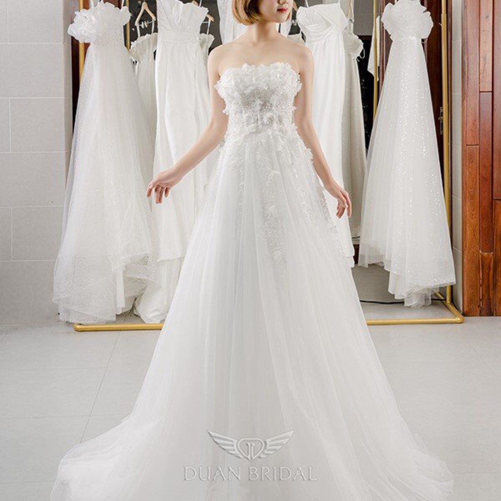 Áo váy cưới màu trắng được thếu bông hoa được làm thủ công trước ngực  tạo nên vẻ đẹp nhẹ nhàng ,thương hiệu DUANBRIDAL