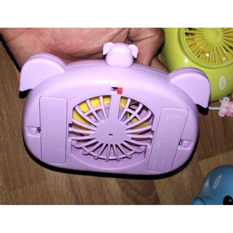 Một chiếc quạt để bàn mini bằng nhựa có dây đeo tặng kèm pin