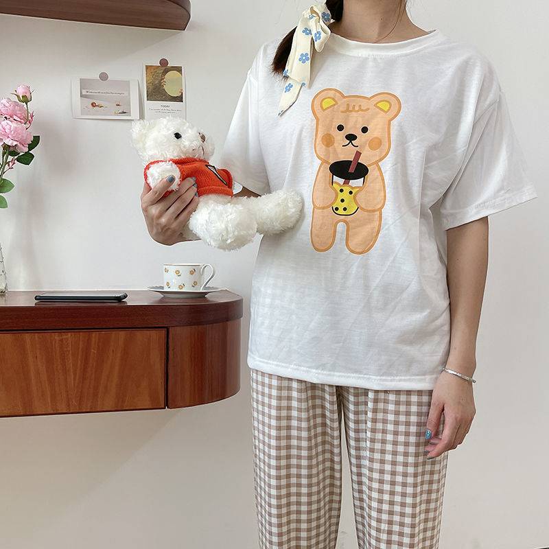 Bộ đồ mặc nhà gồm áo thun ngắn tay họa tiết gấu và quần dài ống rộng kẻ caro cho nữ