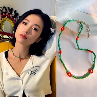 Phụ kiện vòng cổ hoa đan đỏ trên cỏ xanh 🌸