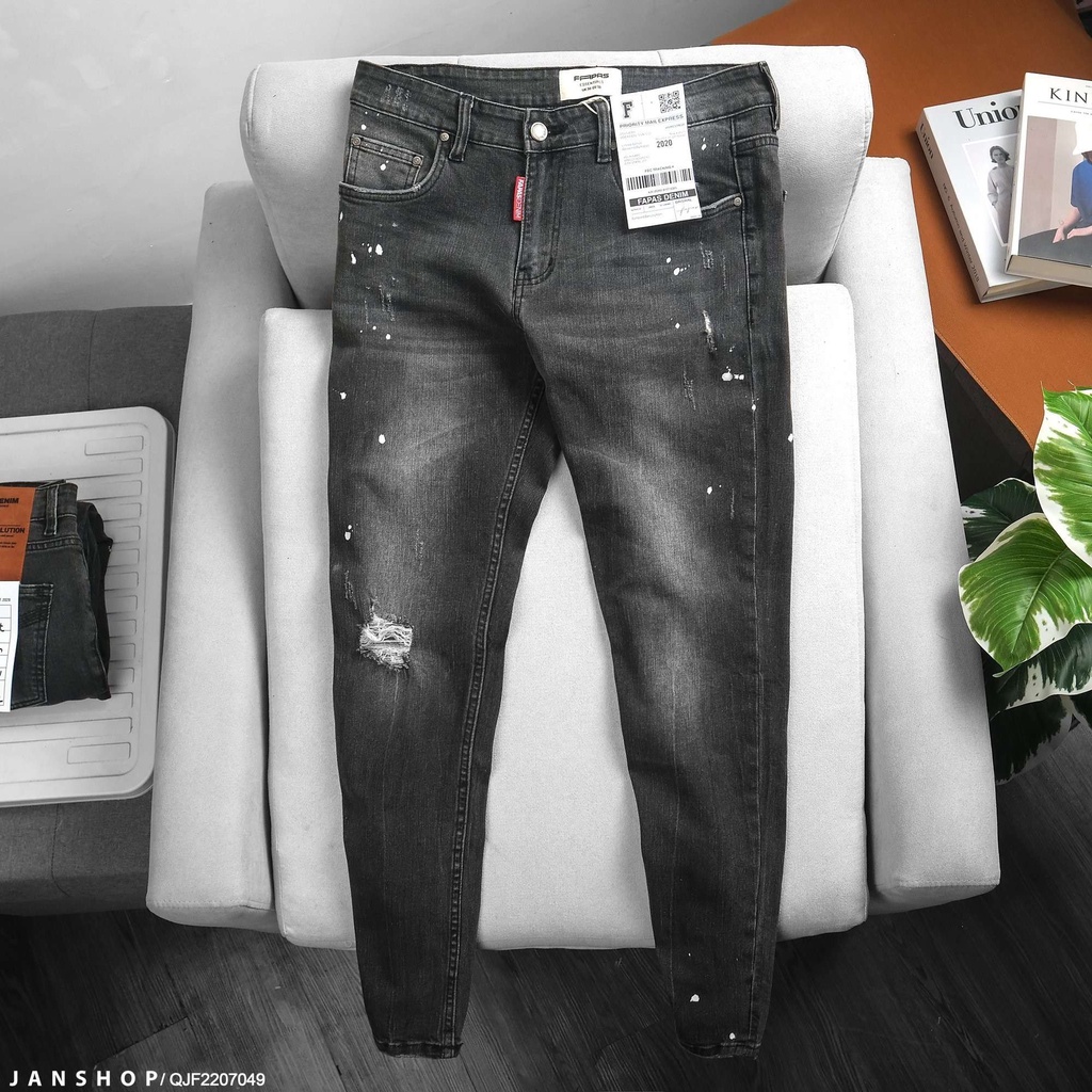 Quần Jean đen form skinny ôm vừa vặn, thiết kế rách gối nhẹ và được nhấn nhá bởi những vệt sơn bụi bặm