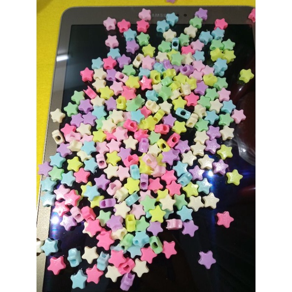 gói 100 hạt nhựa hình ngôi sao đủ màu và 2 mét cước thun dùng để xõ chuỗi đeo tay, hạt có thể làm cài tóc
